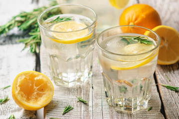 Homemade cold refreshing summer lemonade with rosemary on a white wooden background. Close up and...