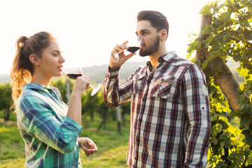 People tasting wine in vineyard