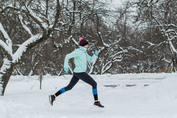 Fototapeta na wymiar Young woman jogging in the winter park