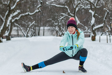Fototapeta na wymiar Young woman warming up before jogging