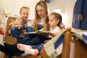 Mom reads a book to his daughters