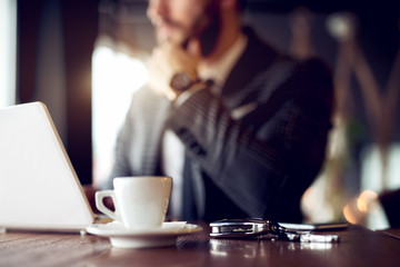 Businessman at restaurant, car key at focus.