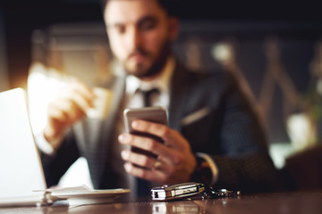 Businessman at restaurant, car key at focus.
