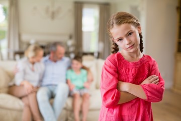 Girl standing with arm crossed in living room
