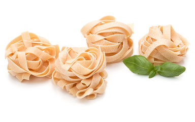 Italian pasta fettuccine nest and basil leaves  isolated on whit