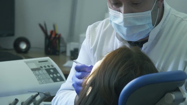 Dentist diagnoses the patient's teeth