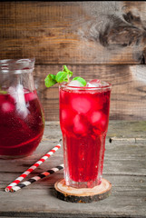 Summer iced drink - tea or juice with ice and mint. On rustic wooden table, copy space