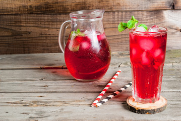 Summer iced drink - tea or juice with ice and mint. On rustic wooden table, copy space