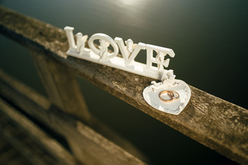 Wedding accessories. newlyweds rings and a wooden plaque in the form of text wedding