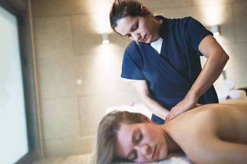 Obraz na płótnie Canvas Masseur massaging back of female