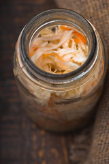 Sauerkraut in a glass jar and rustic napkin close-up