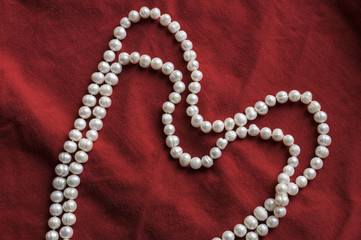 pearls and a pearl necklace on a red background for valentine day