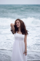 Fototapeta na wymiar Portrait of young brunette woman enjoying sea storm