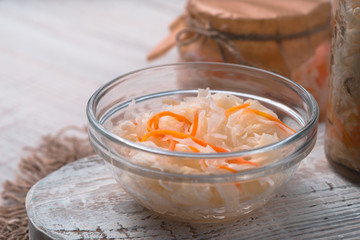 Sauerkraut in a bowl and in the bank on the board close-up