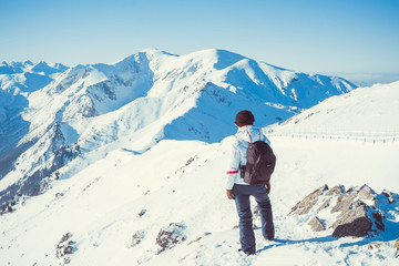 Woman hiker, healthy lifestyle. Trekking and hiking on snow white winter nature, beautiful inspirational mountain landscape.