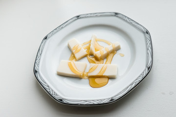 Simple dessert plate of cheese with drizzled honey.