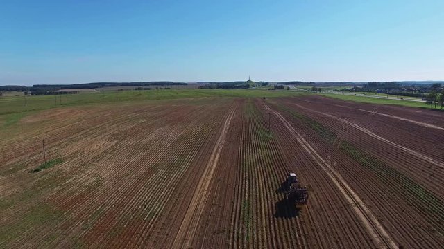 4K. Aerial. Harvesting potatoes with modern potato-digger trailer and tractor.