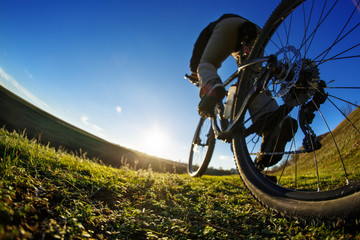 man cyclist stand with mountain bike at sunset