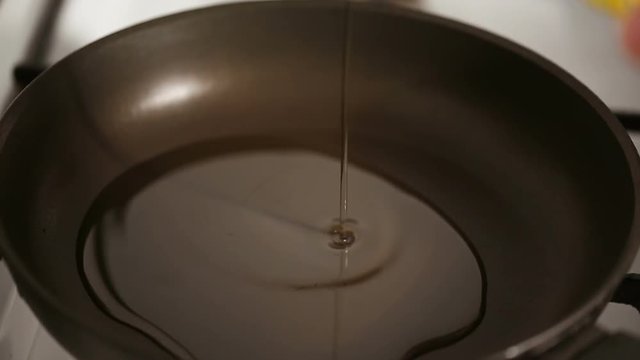 Close up shot of Pouring oil in a frying pan
