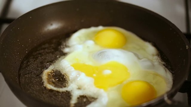 Close up refocusing shot of Preparing scrambled eggs on hot frying pan