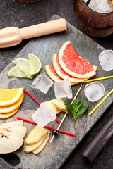Coconut with ice and fresh fruits (grapefruit, kiwi, orange ) and mint over concrete background.