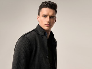 Fashion portrait of a handsome man with trendy hairstyle  in a stylish jacket .