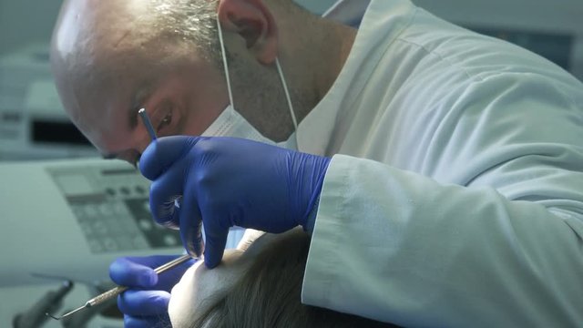 Dentist diagnoses the patient's oral cavity