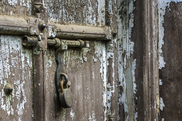 Lock and peeling blue paint on warehouse door in Indian commercial district
