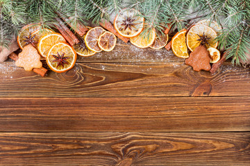 Dried oranges, star anise, cinnamon sticks and gingerbread on a wooden background, sprinkled with artificial snow.-- Christmas still life background