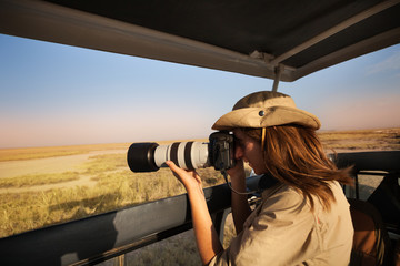 Woman tourist taking photo of African savannah