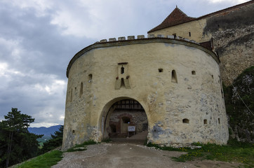 Fototapeta na wymiar Gate tower of medieval fortress in Rasnov with mountains at background, Transylvania, Brasov, Romania
