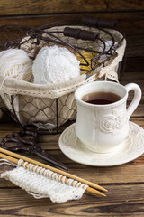 Wool yarn and knitting needles in a vintage basket