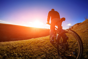 cyclist stand with mountain bike at sunset