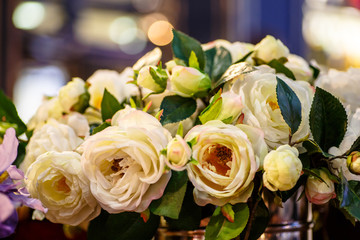 Yellow (cream) rose flowers stand in a large vase. It is possibl