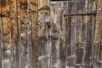 Tür in verwitterter Holzwand eines alten Stalls
