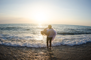 Sea travel, happy couple hugging on  side near hot summer water of ocean. Honeymoon picture with copy space