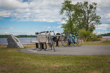 Fototapeta na wymiar Bicycles cycling tourists leaning on a bench by the river at bre
