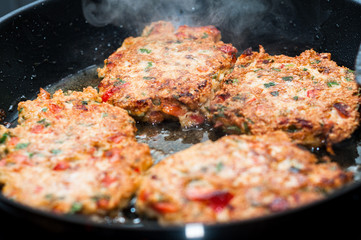 cooking home made meatballs with vegetables in pan on ceramic stove