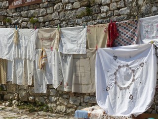 Tovaglie appese davanti ad un muro di pietra in Albania.