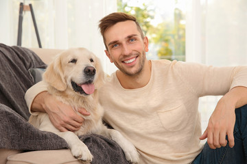 Cool dog and young man having fun at home