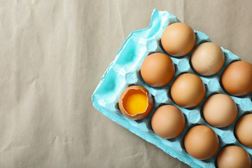Raw eggs in package on craft paper