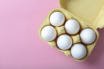 Raw eggs in package on pink background © Africa Studio