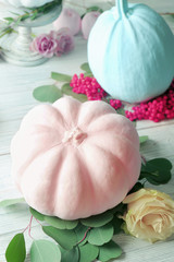 Colourful pumpkins and flowers on white wooden table, closeup