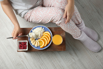 Woman sitting on the floor with healthy breakfast