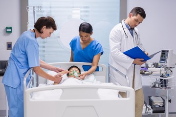 Fototapeta premium Doctors examining patient in ward 