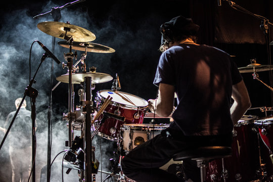 Batterista suona sul palco assolo di batteria durante il concerto, effetto fumo e luci.