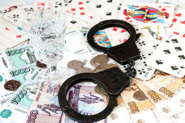 Glass of vodka is handcuffed on the money and cards