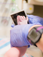 Nurse taking footprint of newborn