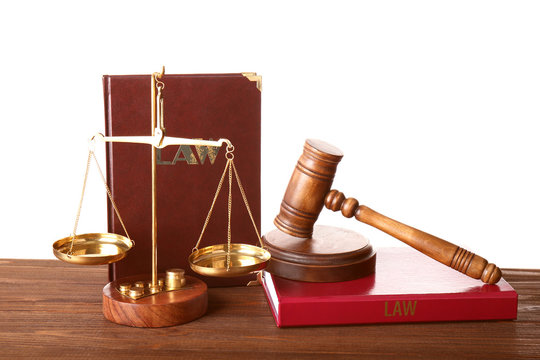 Judge gavel, scales and books on wooden table
