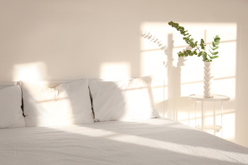 White interior of modern bedroom with cozy double bed